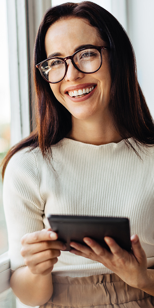 Eine lächelnde junge Frau mit Tablet