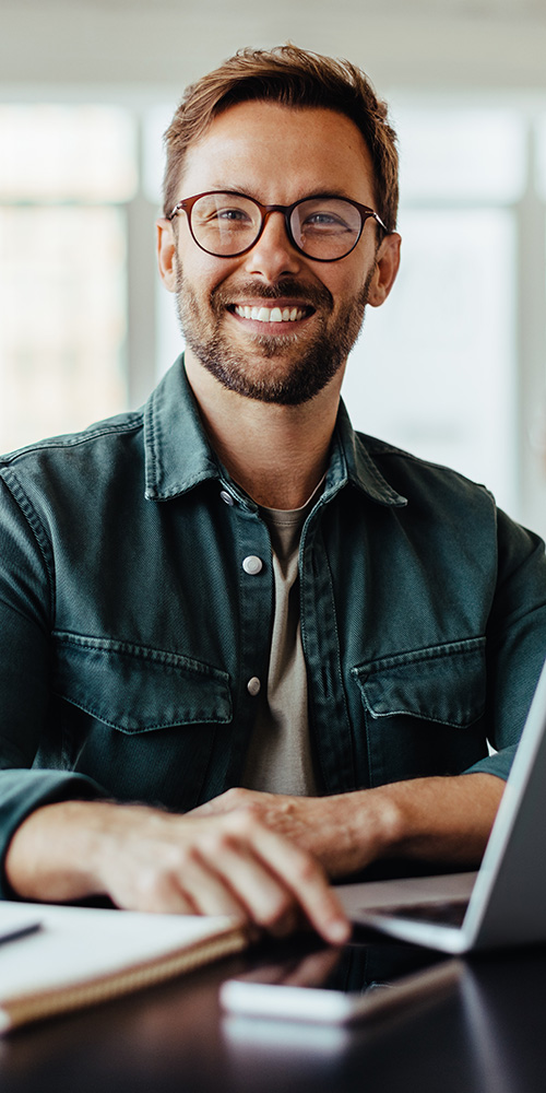 Ein lächelnder junger Mann am Tablet